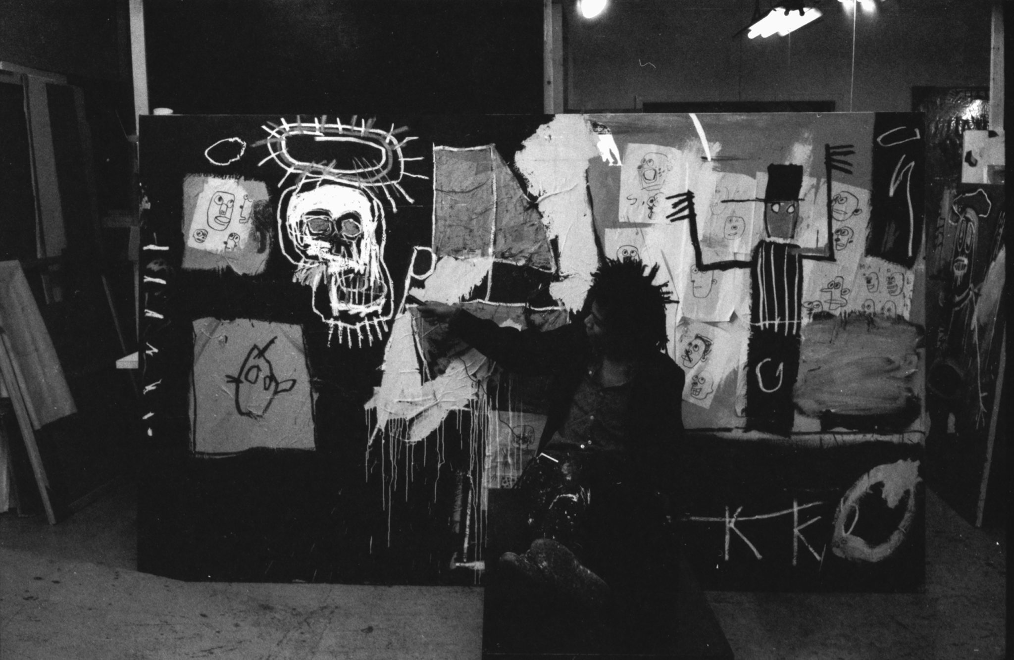 Black and white photograph of Jean-Michel Basquiat in his studio