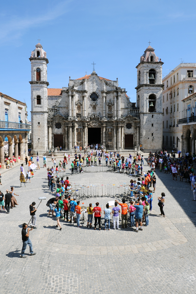Photo of people standing forming Michelangelo Pistoletto Third Paradise symbol in Cathedral Square Havana, Cuba